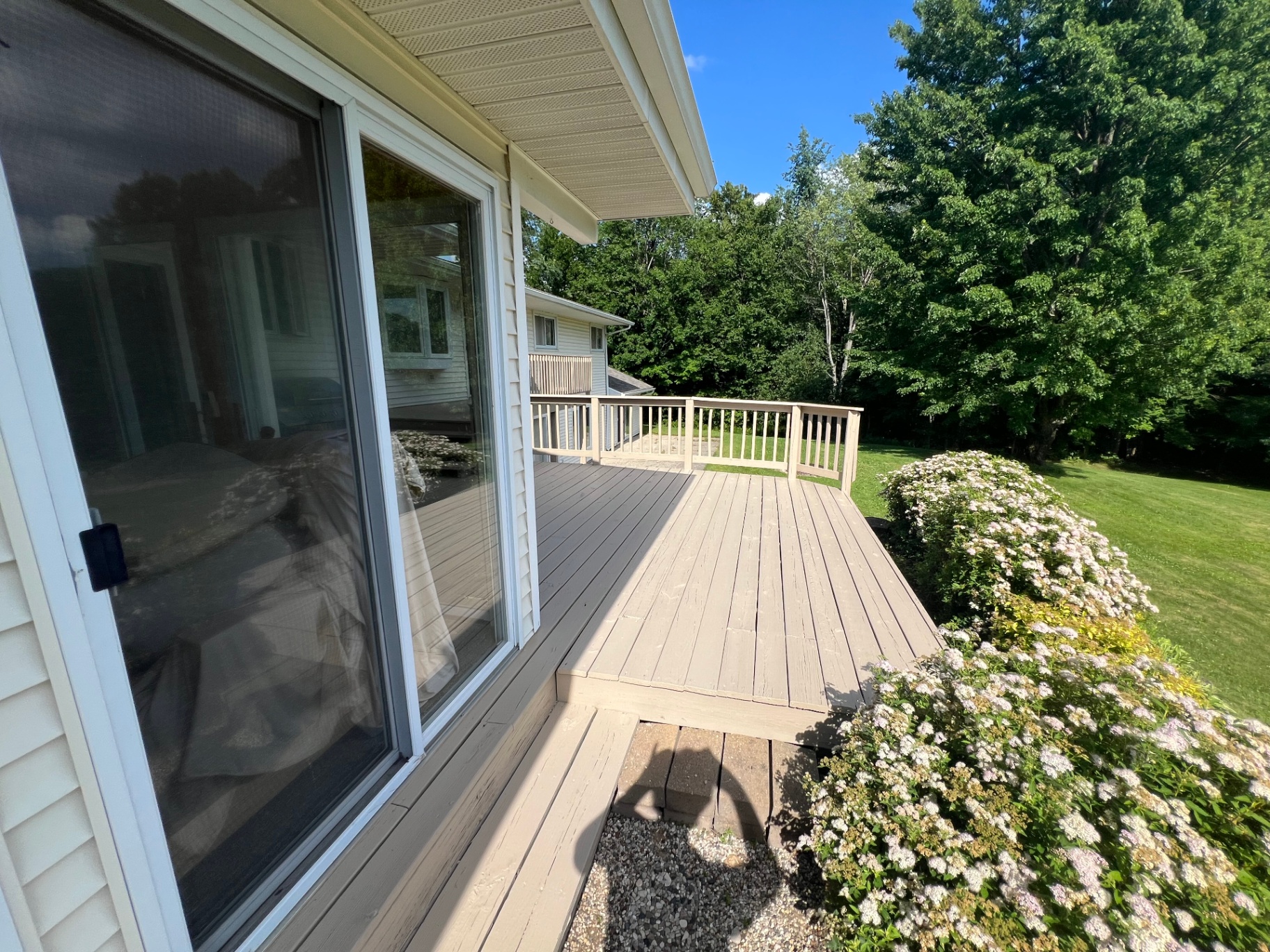 Painted deck boards leading out to landscaped yard